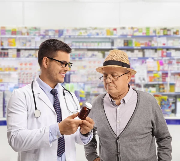 Doctor Showing Bottle Pills Mature Man Pharmacy — Zdjęcie stockowe