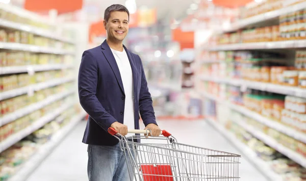 Smiling Young Man Standing Empty Shopping Cart Supermarket — стоковое фото