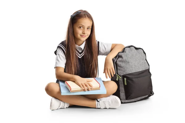 Schoolgirl Sitting Floor Book Her Lap Leaning Backpack Isolated White — Stock fotografie