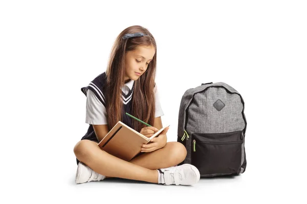 Schoolgirl Sitting Floor Writing Homework Isolated White Background — Foto Stock