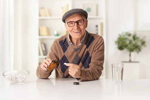 Smiling Elderly Man Sitting Home Taking Pill Bottle — стоковое фото