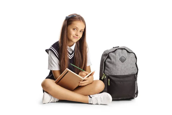 Schoolgirl Sitting Floor Writing Notebook Isolated White Background — Stock fotografie