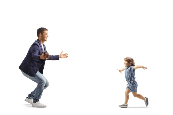 Full length profile shot of a little girl spreading arms and running to her father isolated on white background