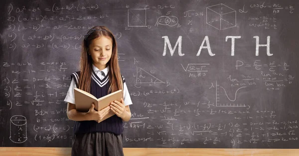 Schoolgirl Reading Book Standing Front Blackboard Geometry Math Formulas —  Fotos de Stock