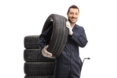 Car mechanic with a tire on his shoulder isolated on white background