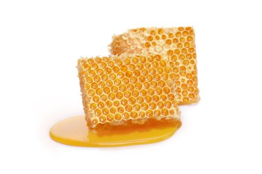 Pieces of a honeycomb with honey leaking around isolated on white background