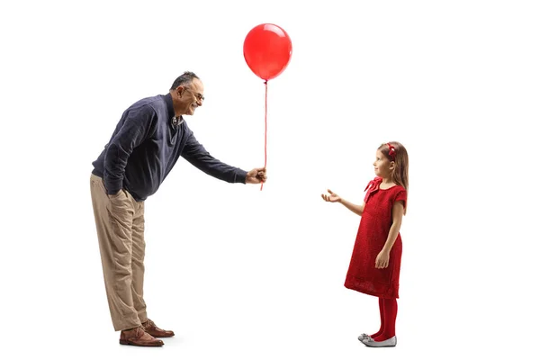 Full Length Profile Shot Mature Man Giving Red Balloon Girl — Zdjęcie stockowe