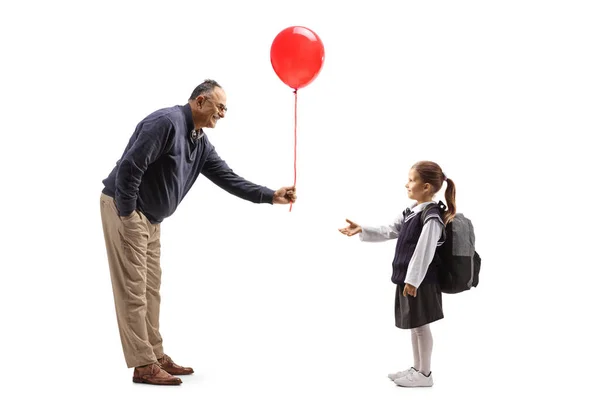 Full Length Profile Shot Mature Man Giving Red Balloon Schoolgirl — Stockfoto