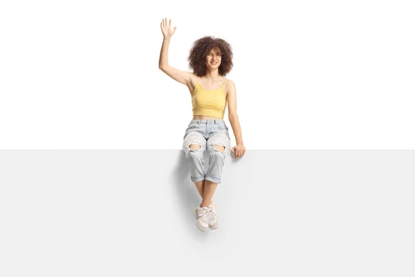 Young Caucasian Female Afro Hairstyle Sitting Blank Panel Waving Isolated — Fotografia de Stock