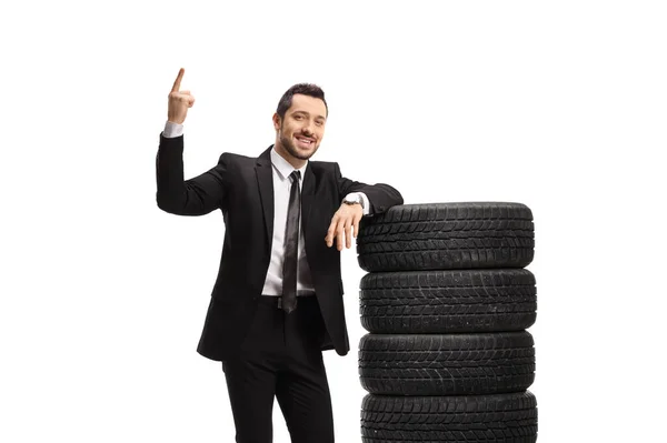 Businessman Pointing Leaning Pile Car Tires Isolated White Background — Foto Stock