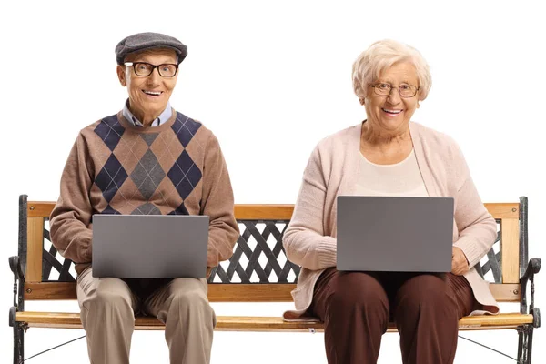 Elderly husband and wife sitting on a bench and using laptop computers isolated on white background