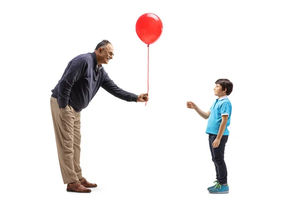 Full Length Profile Shot Mature Man Giving Red Balloon Boy — Stock Photo, Image