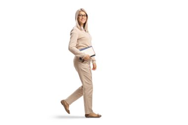 Full length shot of a young female holding books and walking isolated on white background