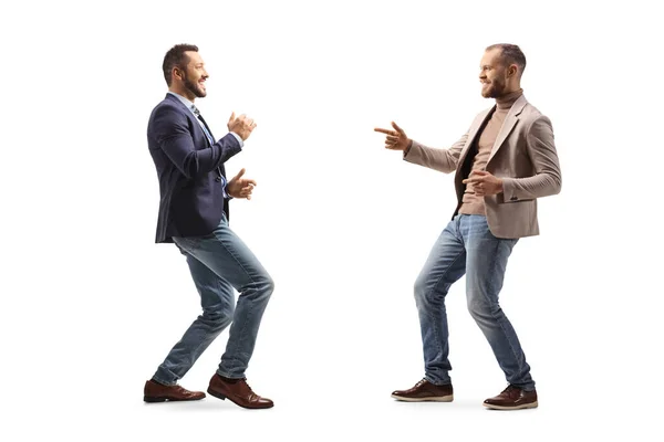 Full length profile shot of two young professional men dancing isolated on white background