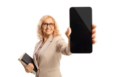 Female teacher holding books and showing a smartphone isolated on white background