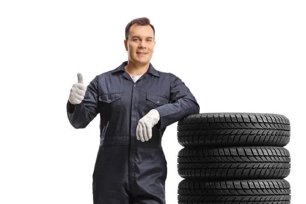 Car Mechanic Uniform Leaning Pile Tires Showing Thumb Gesture Isolated — Stock Photo, Image