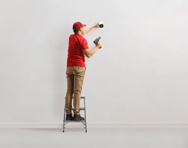 Trabalhador Uma Escada Instalar Uma Câmera Segurança Uma Parede — Fotografia de Stock