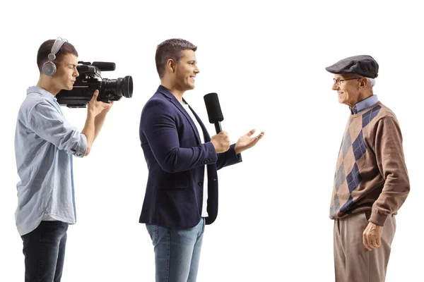 Cameraman Een Mannelijke Verslaggever Interviewen Een Gepensioneerde Geïsoleerd Witte Achtergrond — Stockfoto