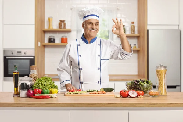 厨师摆好姿势 在厨房柜台前摆弄蔬菜 在白色的背景上给彼此隔离的人做手势 — 图库照片