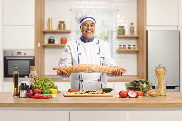 Chef Maduro Alegre Segurando Pão Atrás Balcão Cozinha Sorrindo Para — Fotografia de Stock