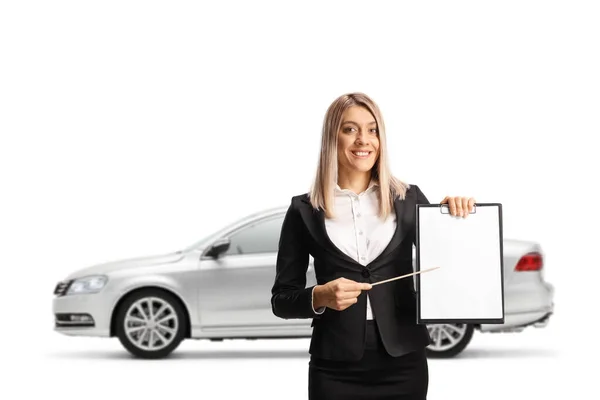 白い背景に孤立した銀車の前でクリップボードを持つ文書を提示ビジネスマンの女性 — ストック写真