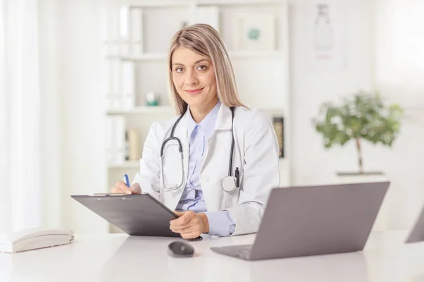 Jovem Médica Sentada Escritório Escrevendo Documento Uma Mesa Com Computador — Fotografia de Stock