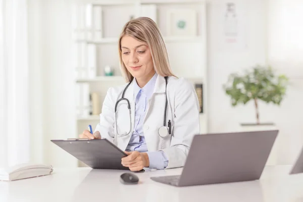 Jovem Médica Sentada Escritório Escrevendo Documento Com Computador Portátil Mesa — Fotografia de Stock