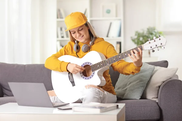 Nastolatka Gitarą Akustyczną Słuchawkami Bawiąca Się Przed Laptopem Domu — Zdjęcie stockowe