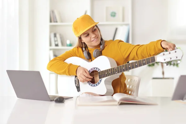 Девочка Подросток Настраивает Акустическую Гитару Перед Ноутбуком Дома — стоковое фото