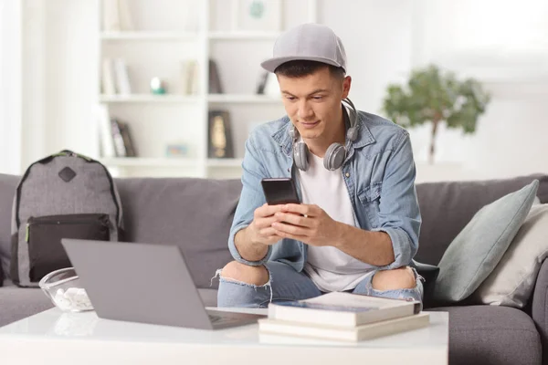 Teenager Mit Smartphone Auf Einem Sofa Sitzend Mit Laptop Auf — Stockfoto