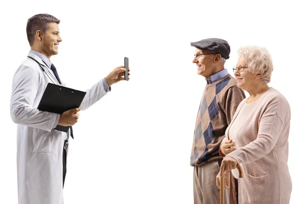 Ung Läkare Visar Mobiltelefon För Äldre Patienter Isolerad Vit Bakgrund — Stockfoto