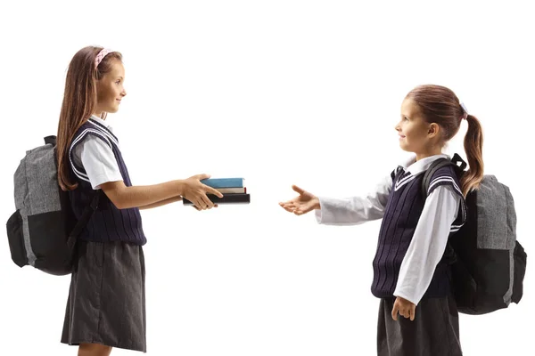 Older Girl Giving Books Younger Schoolgirl Isolated White Background — Stock Photo, Image