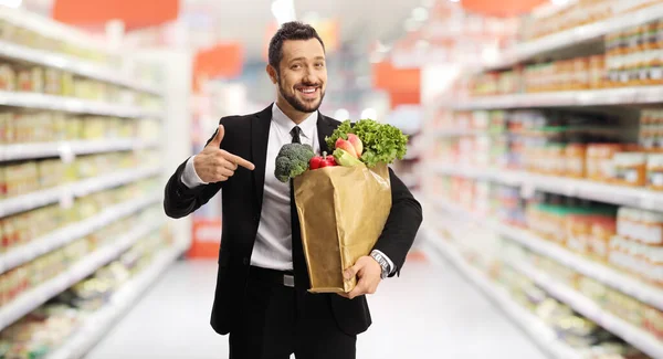 Podnikatel Drží Papírový Sáček Potravinami Ukazuje Supermarketu — Stock fotografie