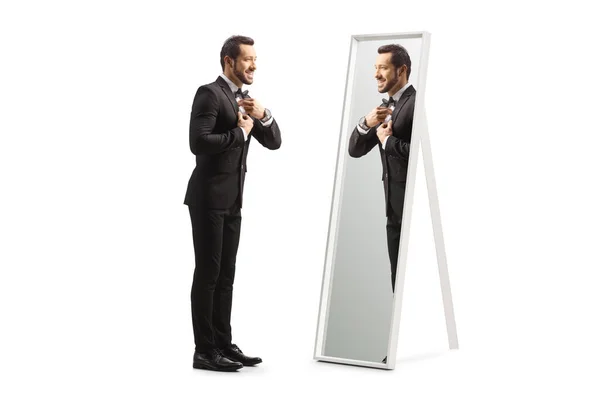 一个年轻优雅的男子在一面白色背景隔离的镜子前准备拍摄的全长轮廓 — 图库照片