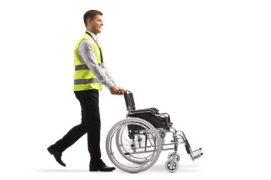 Beyaz arka planda izole edilmiş boş bir tekerlekli sandalye iten havaalanı çalışanı