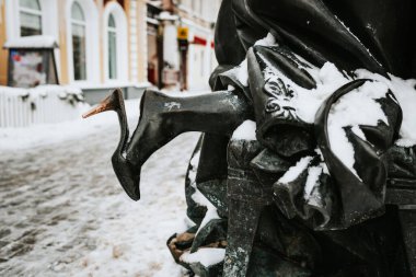 Detail of bronze sculpture of Tambov Treasurer's woman monument. Foot in shoe sticking out from under dress. Tambov, Russia.