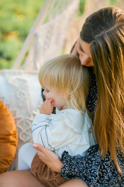 Güzel, genç bir anne ve iki yaşındaki küçük kızı açık havada piknik yapıyorlar. Yaz.
