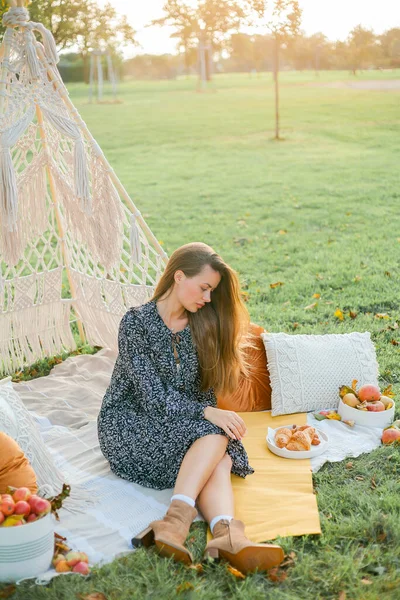 Beautiful young woman on picnic outdoors boho style. Summer.