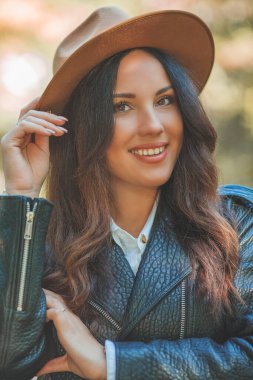 Genç, güzel, koyu renk saçlı kadın sonbahar parkında yürüyor. Düş.