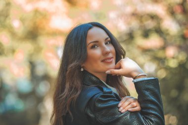 Genç, güzel, koyu renk saçlı kadın sonbahar parkında yürüyor. Düş.