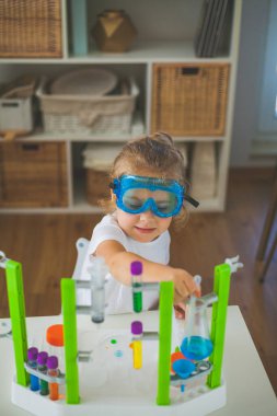 - Bilim. Küçük tatlı kız evde deneyler yapıyor. Renkli sıvılar, laboratuvar çocuk tesisatı. Okul.