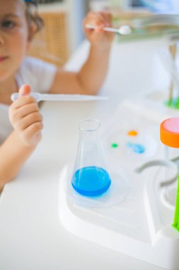 - Bilim. Küçük tatlı kız evde deneyler yapıyor. Renkli sıvılar, laboratuvar çocuk tesisatı. Okul.