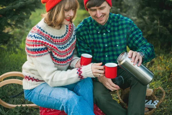 Święta Szczęśliwa Młoda Para Zakochana Czerwonych Kapeluszach Swetrach Pije Gorącą — Zdjęcie stockowe