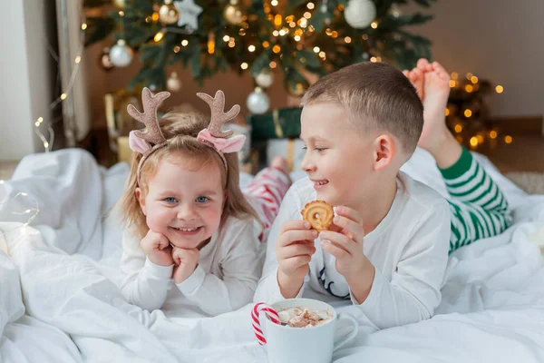 크리스마스 잠옷을 스러운 소녀가 크리스마스 장식에 마시멜로와 롤리팝 뜨거운 코코아를 — 스톡 사진