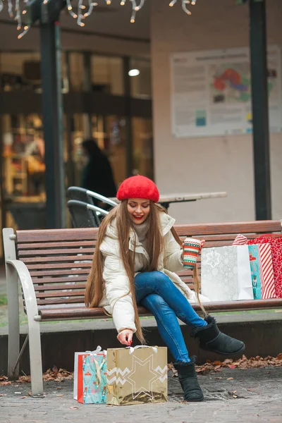 年轻而美丽的时尚女子在欧洲城市过冬时手持圣诞购物袋的街头肖像画 长发休闲服的时尚模特 — 图库照片