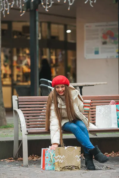 年轻而美丽的时尚女子在欧洲城市过冬时手持圣诞购物袋的街头肖像画 长发休闲服的时尚模特 — 图库照片