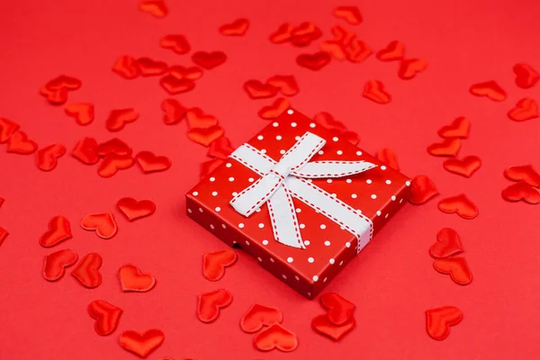 San Valentín flatlay. Caja de regalo roja con lazo, corazones de San Valentín sobre fondo rojo. — Foto de Stock
