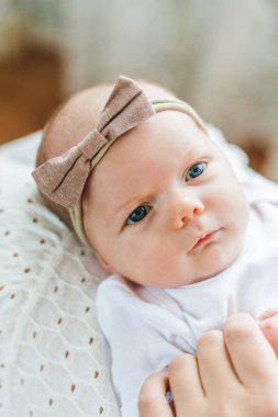 Mavi gözlü genç ve güzel bir anne yeni doğmuş kızını kollarında tutuyor. Annelik. Dikkat et. Bebeğim..