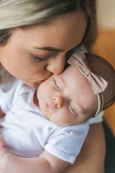 Mladá krásná matka s modrýma očima drží svou novorozenou dcerku v náručí. Mateřství. Opatrně. Baby. — Stock fotografie