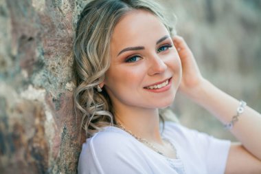 Genç, güzel mavi gözlü sarışın bir Avrupa şehrinin merkezinde. Sıradan kıyafetler içinde şık bir modelin portresi. Mutlu gençlik. Şehir.